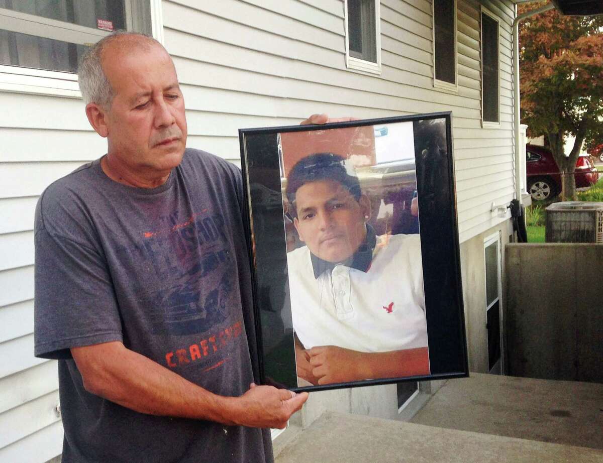 In this Sept. 27, 2016 photo, Abraham Chaparro, holds a photograph of his murdered stepson, Miguel Garcia-Moran, outside his home in Brentwood, N.Y. The remains of Garcia-Moran, who was reported missing in February, were found in September. Multiple teenagers from the same Long Island high school have been found dead and while police suspect all the deaths are related to gang violence, they are releasing few details. (AP Photo/Claudia Torrens) ORG XMIT: RPCT102