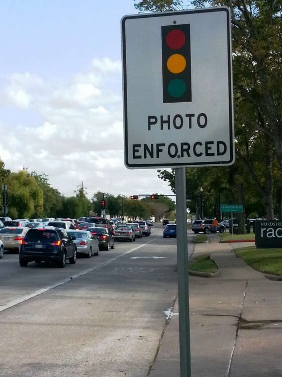 A sign announces the presence of a red ligh camera to drivers on State Highway 6 near its intersection with Lexington Boulevard.