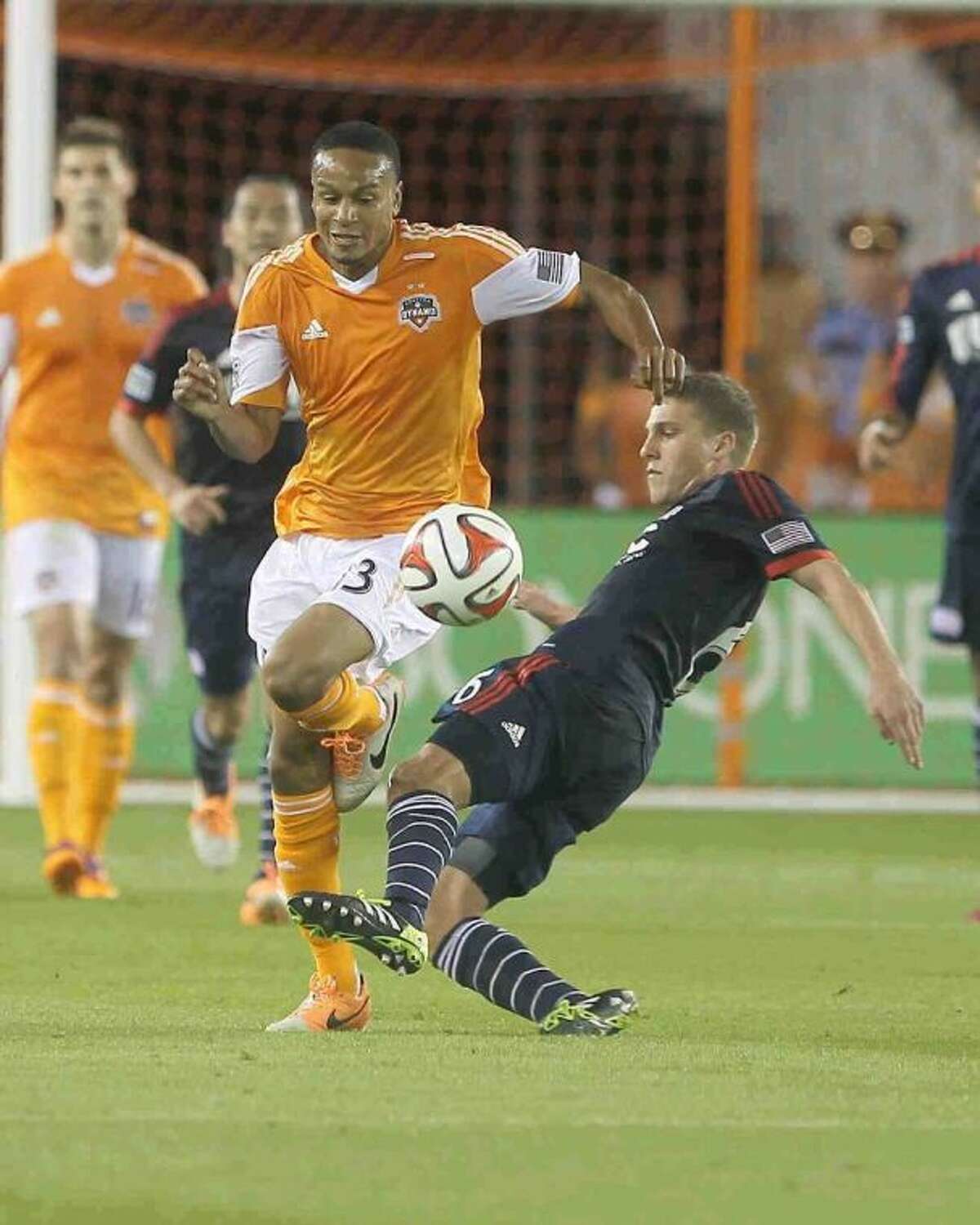 New England Revolution midfielder Scott Caldwell (6) goes for the ball against Houston Dynamo midfielder Ricardo Clark (13) during the first half of an MLS soccer game Saturday. The Dynamo won 4-0.