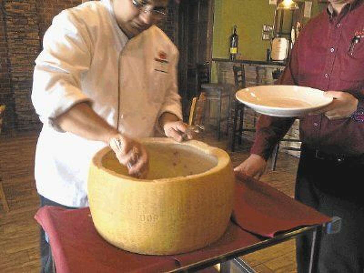 Chef Omar Alvarado grates parmigiano-reggiano tableside from a cheese wheel imported from Italy.