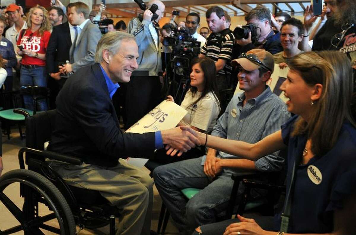 Republican gubernatorial candidate Greg Abbott, left, greets supporters during a campaign stop in downtown Wichita Falls, Texas Tuesday, Feb. 18, 2014. Wendy Davis is the Democratic opponent.