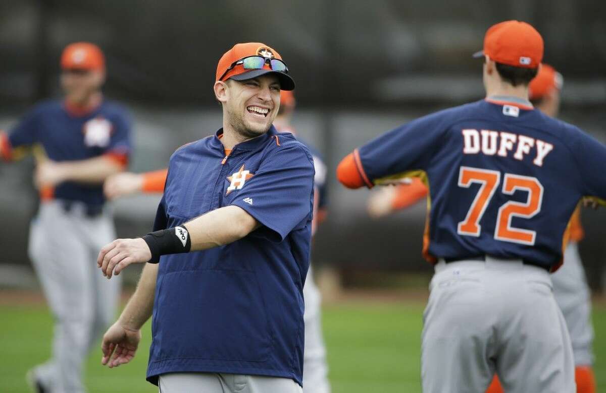 Houston Astros’ Jed Lowrie smiles while stretching with teammates during a spring training baseball workout Thursday in Kissimmee, Fla.