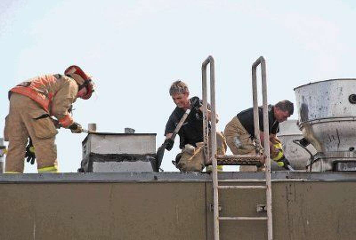 Houston Firefighters work on the roof of the 888 Bistro Chinese restaurant after an early morning fire Monday.