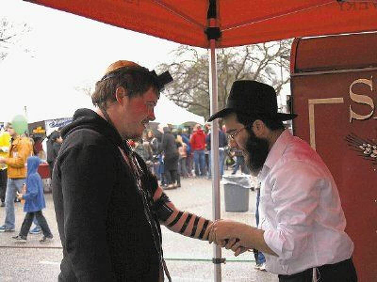 Neftali Junik places the Tefillin on Schafer Edwards at the Kosher Chili Cookoff on March 8th.