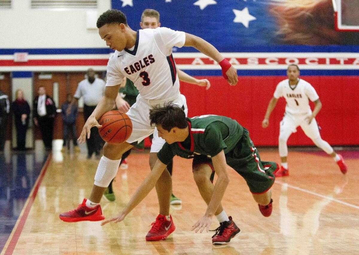 Atascocita point guard Carsen Edwards stips the ball away from The Woodlands guard Clay Creighton during the first quarter of a basketball game at Atascocita High School Tuesday.