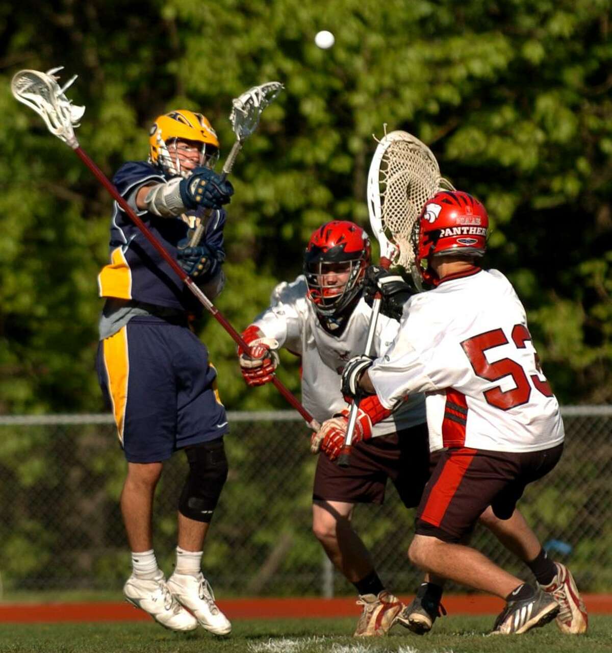 Weston's Jack Scheufele, left, send the ball past Masuk goalie Charles Porzelt for a goal, during lacrosse action in Monroe, Conn. on Friday May 07, 2010. Trying to block in the middle is Masuk's #3 Tim Treschitta.