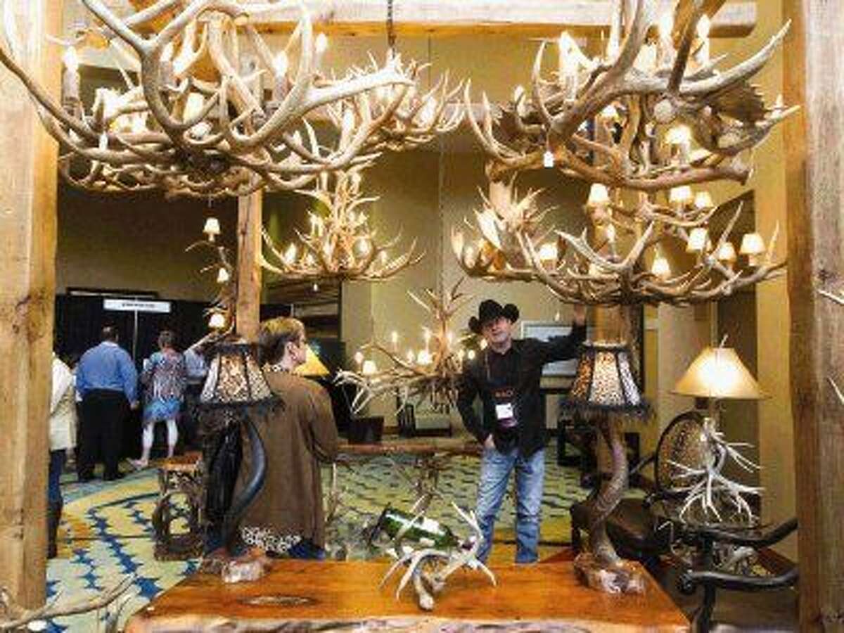 Terry Wilson, owner of Terry Wilson Antler Designs, shows visitors various pieces during the Houston Safari Club's annual convention Saturday.