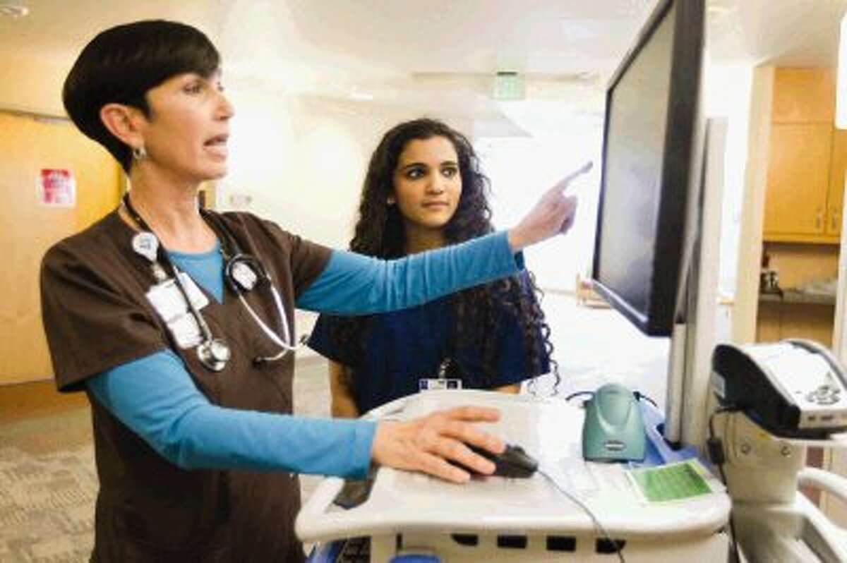Staff Nurse Jan Bates shows Ashri Anurudran the hospital’s computer system at St. Luke’s Hospital in The Woodlands Wednesday.