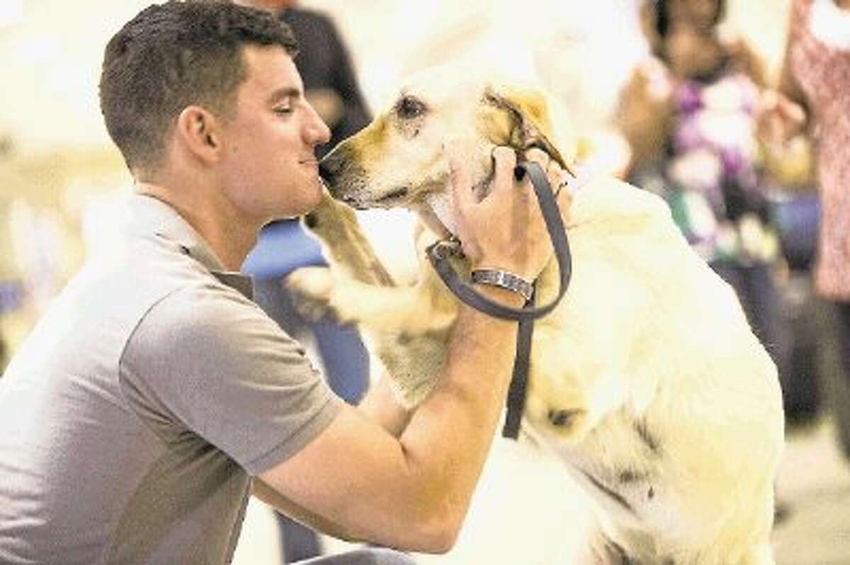 U.S. Marine Cpl. Joaquin Aranda is reunited with his military war dog, Donna, on June 21, 2014, at Houston Hobby Airport. This reunion was facilitated by the American Humane Association and Mission K9 Rescue with a mission to reconnect service dogs with their handlers.