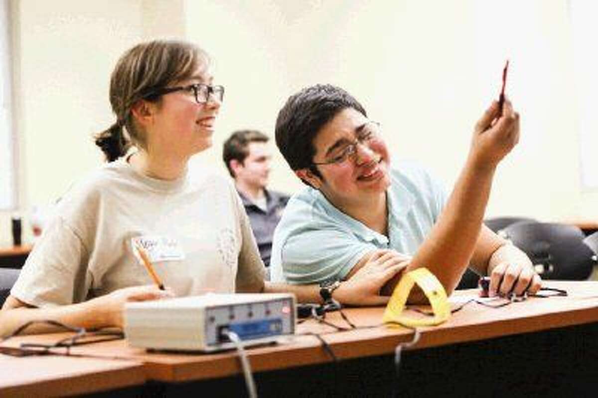 Conroe High School students Antonio Gaddie, right, and Megan Martin laugh while competing in the Science Bowl during the Education for Tomorrow Alliance’s SCI://TECH Exposition Friday at Lone Star College-Montgomery.