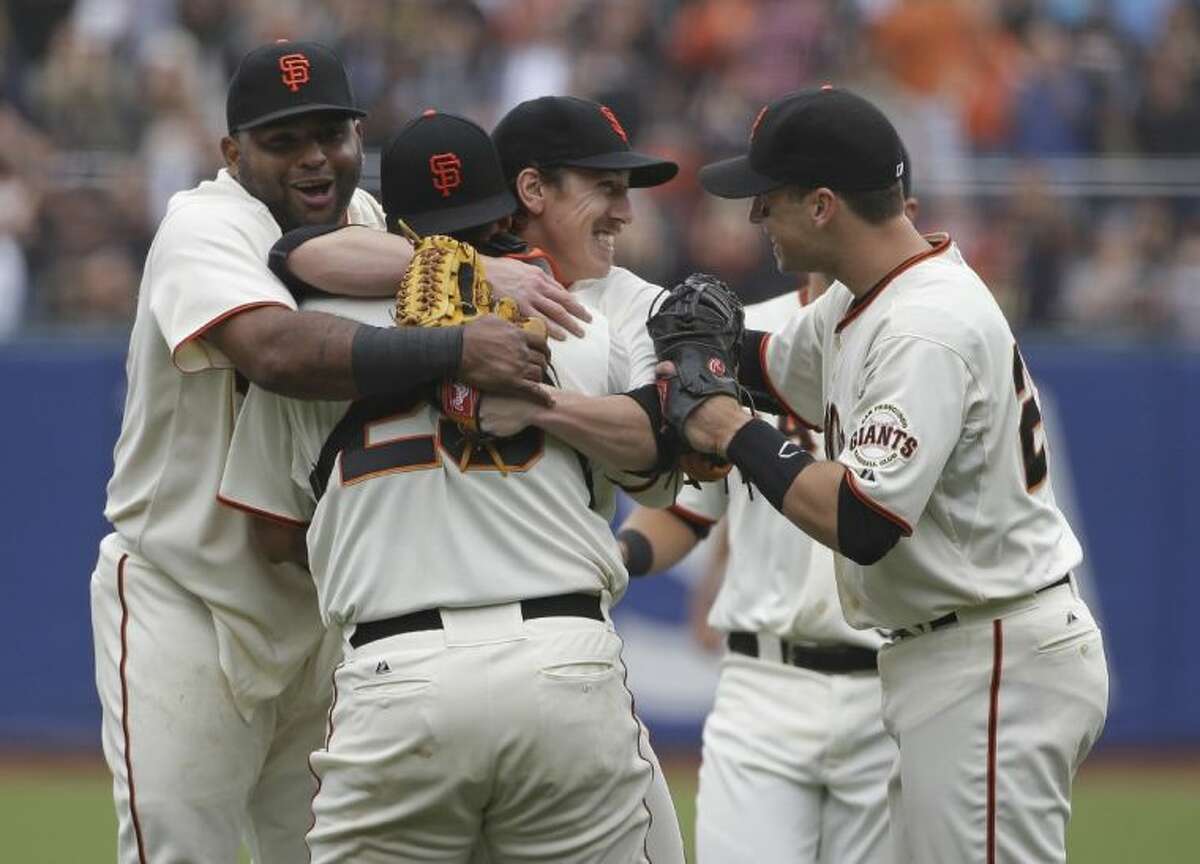 San Francisco Giants players, from left, Pablo Sandoval, Hector Sanchez and Buster Posey swarm pitcher Tim Lincecum after his no-hitter against the San Diego Padres on Wednesday in San Francisco.