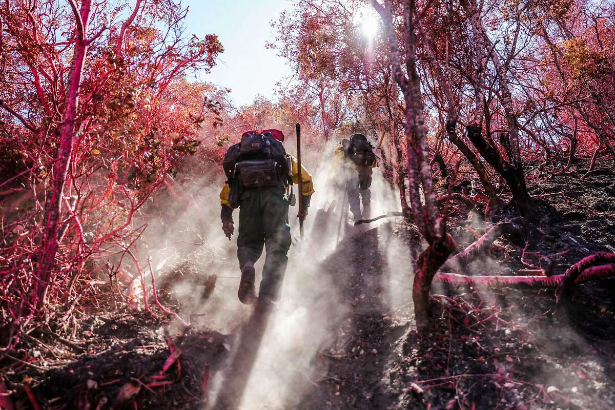 Firefighters John Waybright (right) and Keith Abara (left) traverse a forested area while looking for hot spots caused by the Soberanes Fire, in Monterey, California, on Thursday, Sept. 29, 2016.