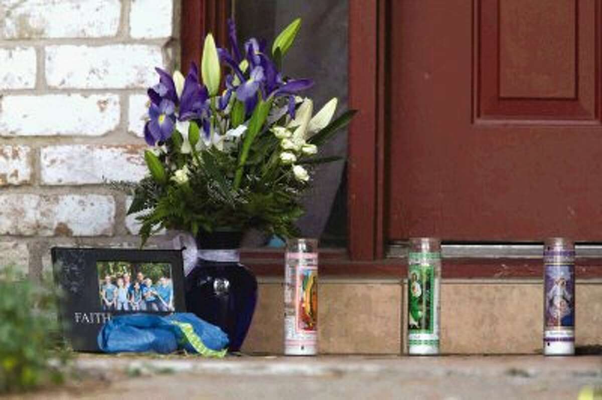 Candles, flowers and a framed family photo sits on the doorstep of a home where six people were shot Thursday in Spring. Four children and two adults were killed Wednesday after an apparent domestic dispute.