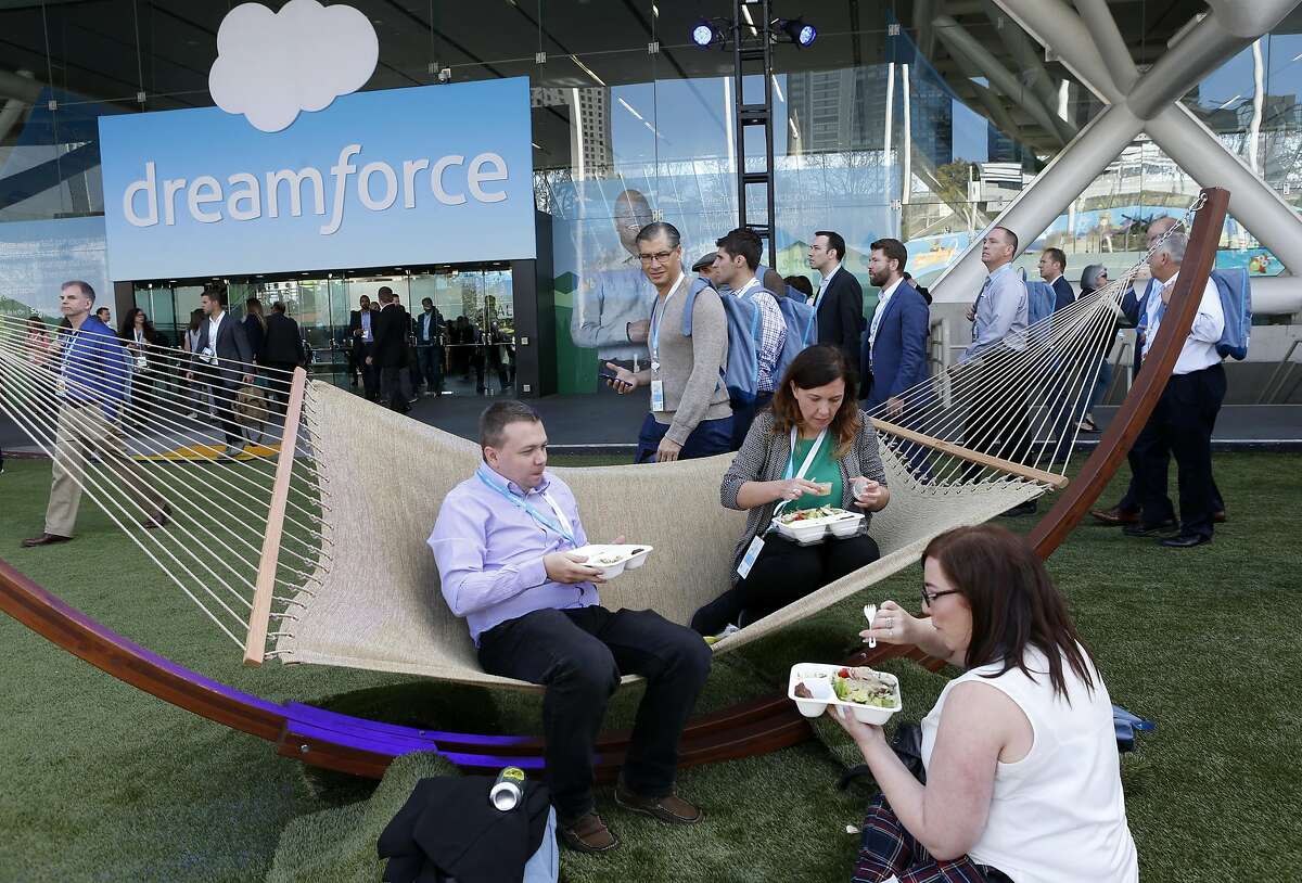 Simon Driscoll and Nicola Band, from Scotland, settle into a hammock for lunch with colleague Freya Crawshaw at the Dreamforce conference hosted by Salesforce at the Moscone Convention Center in San Francisco, Calif. on Tuesday, Oct. 4, 2016.