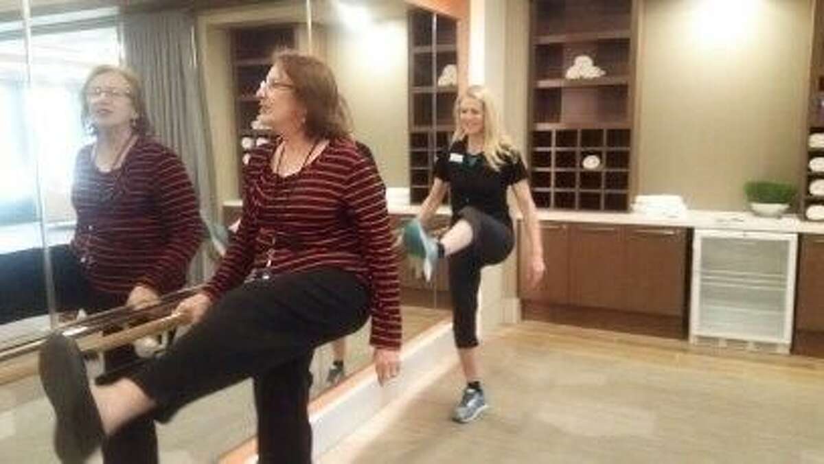 Terrie Neill, a resident at Avanti Senior Lving, exercises with fitness coordinator Charlotte Byrne.