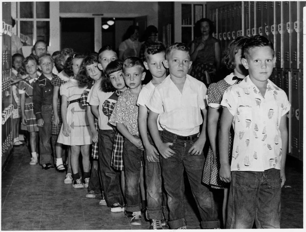 Children line up for a polio vaccine designed by Dr. Jonas Salk, of the University of Pittsburgh, at Hohl Elementary School in Houston in 1955. (Houston Chronicle file photo)