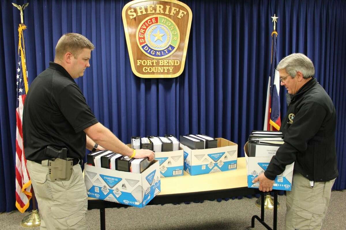 Fort Bend County Sheriff’s Office Sgt. Rodney Grimmer, left, and Lt. David Schultz, right, are shown with just a portion of the records reviewed in Lamar CISD case.