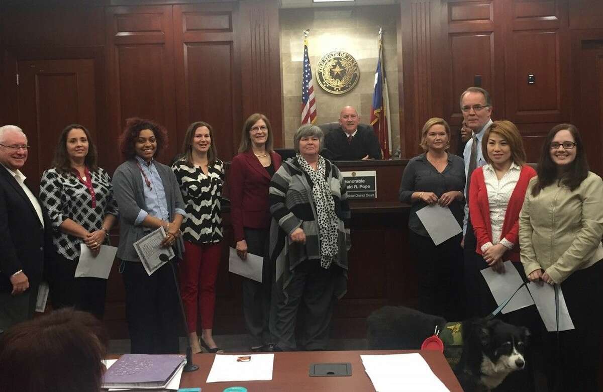 Recently trained volunteers shown with Judge Ronald Pope of the 328th Judicial District Court are Donald May, Donna Yeaman, Phelisha Constantini, Heather Lovell, Susan Brown, Corinne Light, Kellye Blankenship, Sigrid Walker, Lee Semones, Nikki Huynh, and Bethany Moers.
