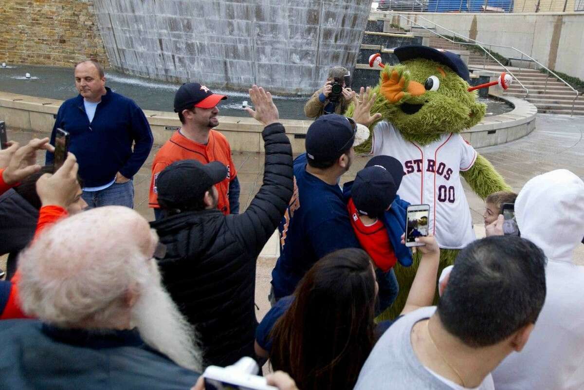 Houston Astros mascot Orbit gives fans high-fives during an Astros Caravan stop at The Woodlands Waterway Thursday.