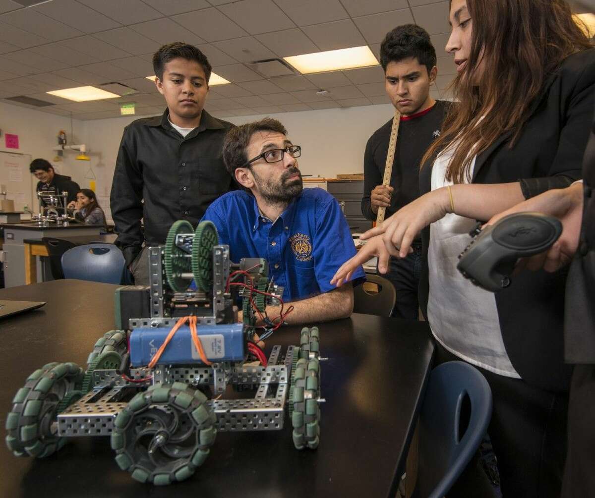 HISD Secondary Teacher of the Year Vladimir Lopez works with students on a robotics project.