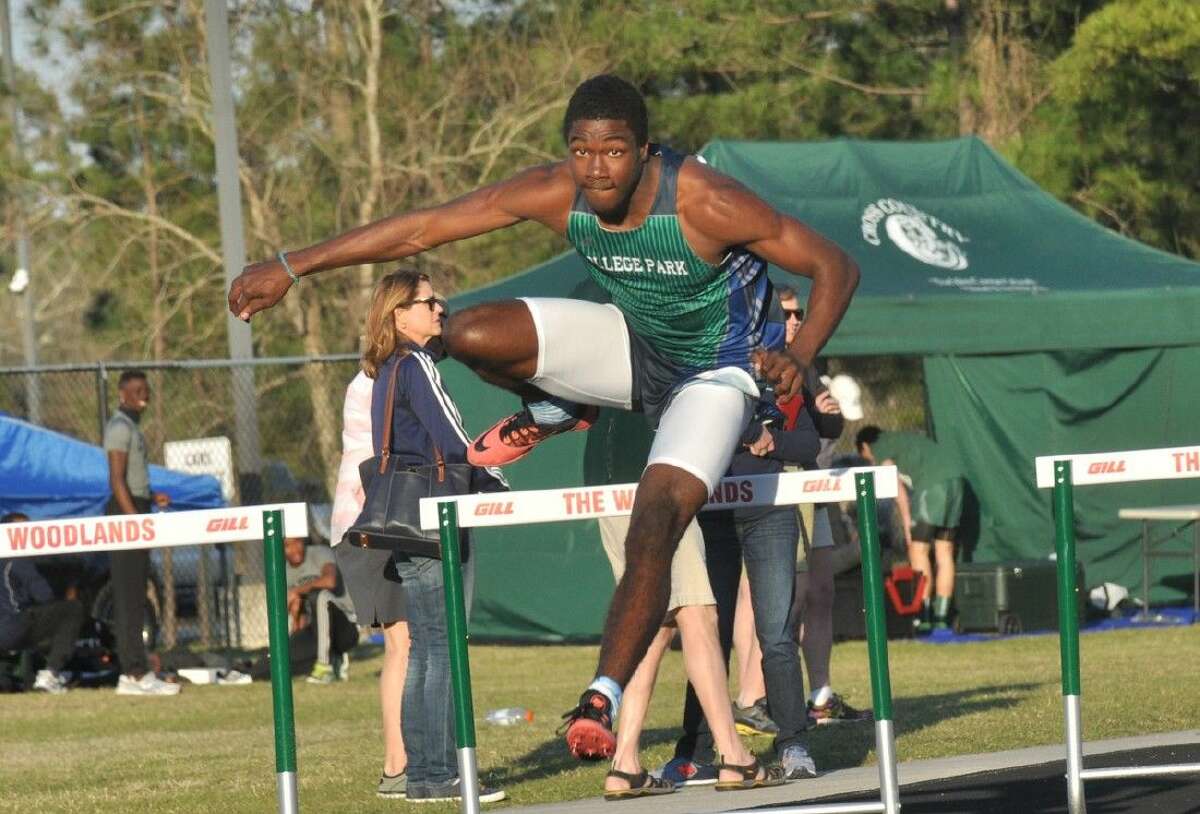 College Park's Joshua Holman clears a hurdle in the 300-meter hurdles at the Highlander Invitational track and field meet at The Woodlands High School earlier this season.