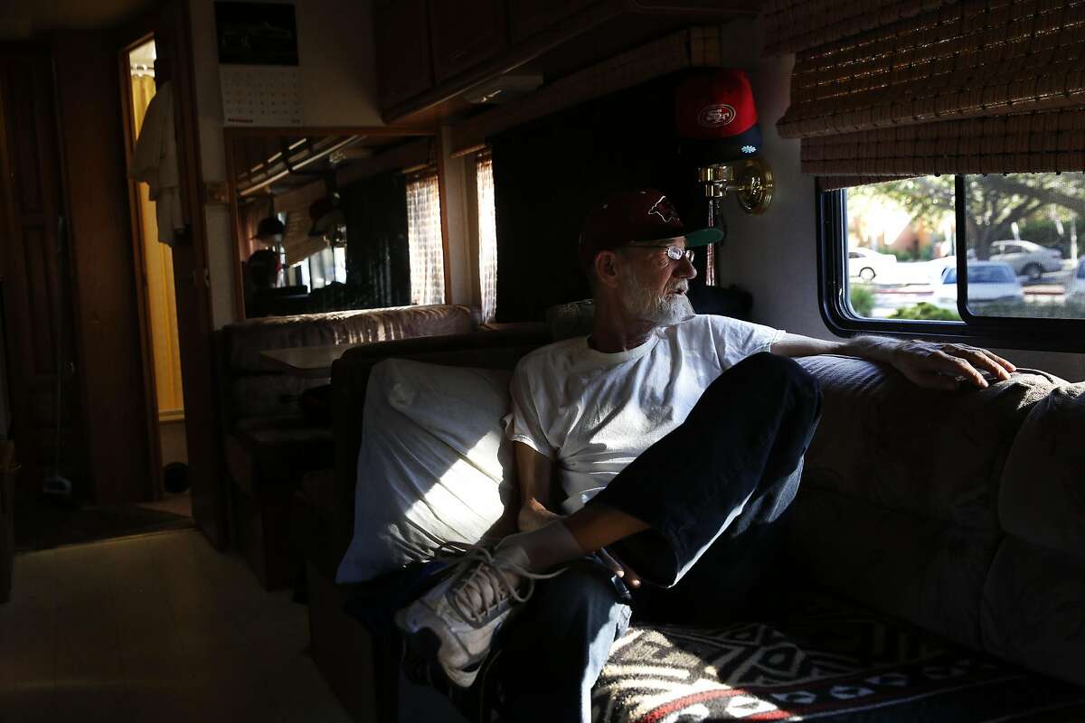 Scotty Whaley looks out the window of his RV, where he currently lives on Crisanto Ave. where nearly 40 RVs and vehicles are parked next to Rengstorff Park Oct. 4, 2016 in Mountain View, Calif. Whaley, who used to live in a van, spent his savings to buy the RV so that he could afford a place to live.