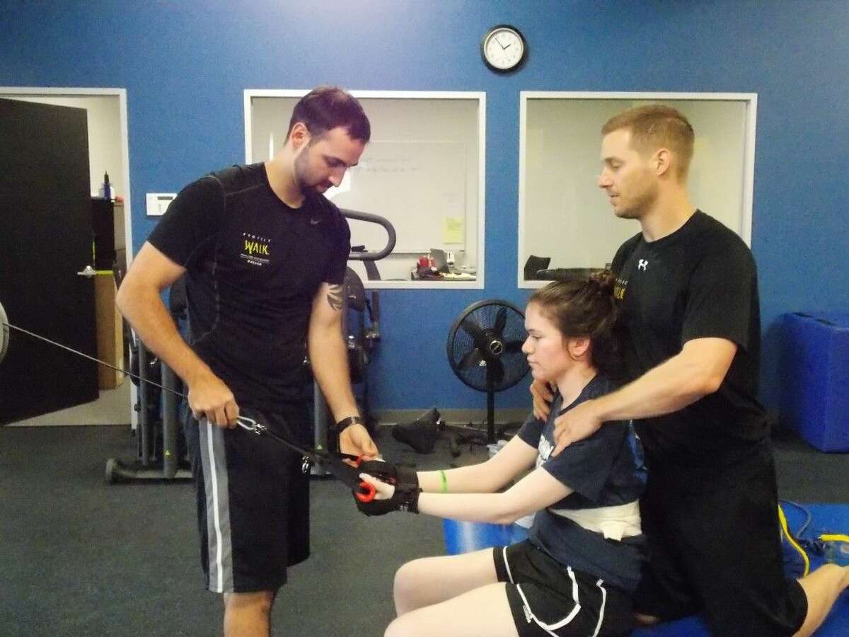 From left, trainer Kris Vierra, client Kayla Goldwitz and trainer Ross LaBove. Project Walk features individually designed training regimens for its paralyzed clients.