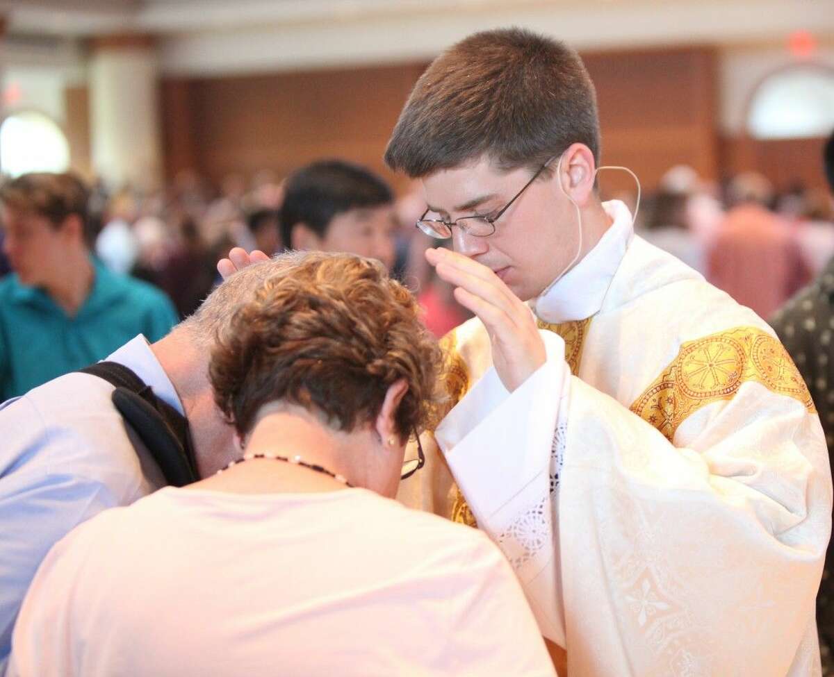 Fr. David Angelino blesses Deacon Alfredo Soto and his wife Irene following his first Mass at St. Martha in Kingwood June 7, 2015.