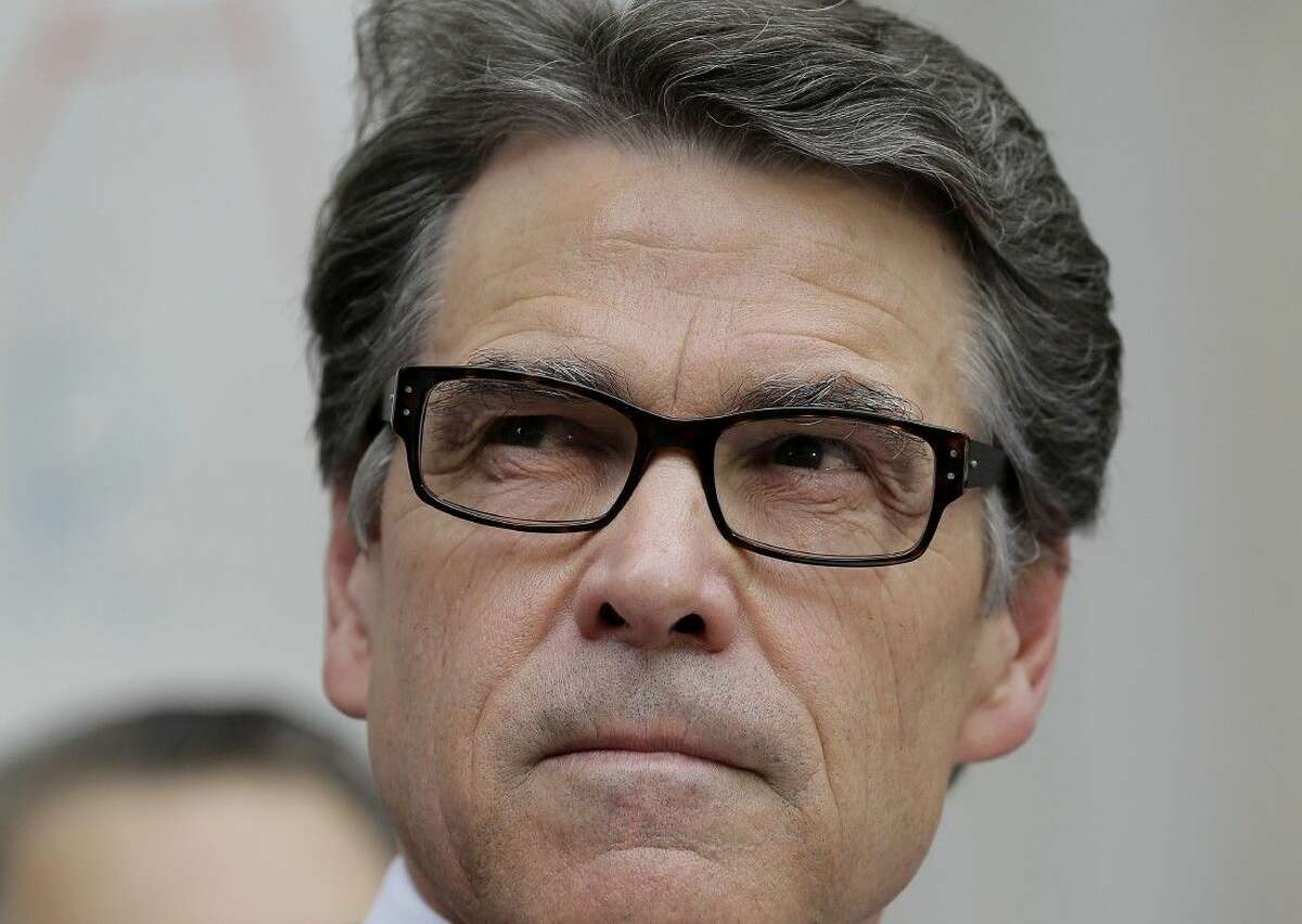 Texas Gov. Rick Perry talks with media and supporters at the Blackwell Thurman Criminal Justice Center after he was booked Tuesday in Austin.