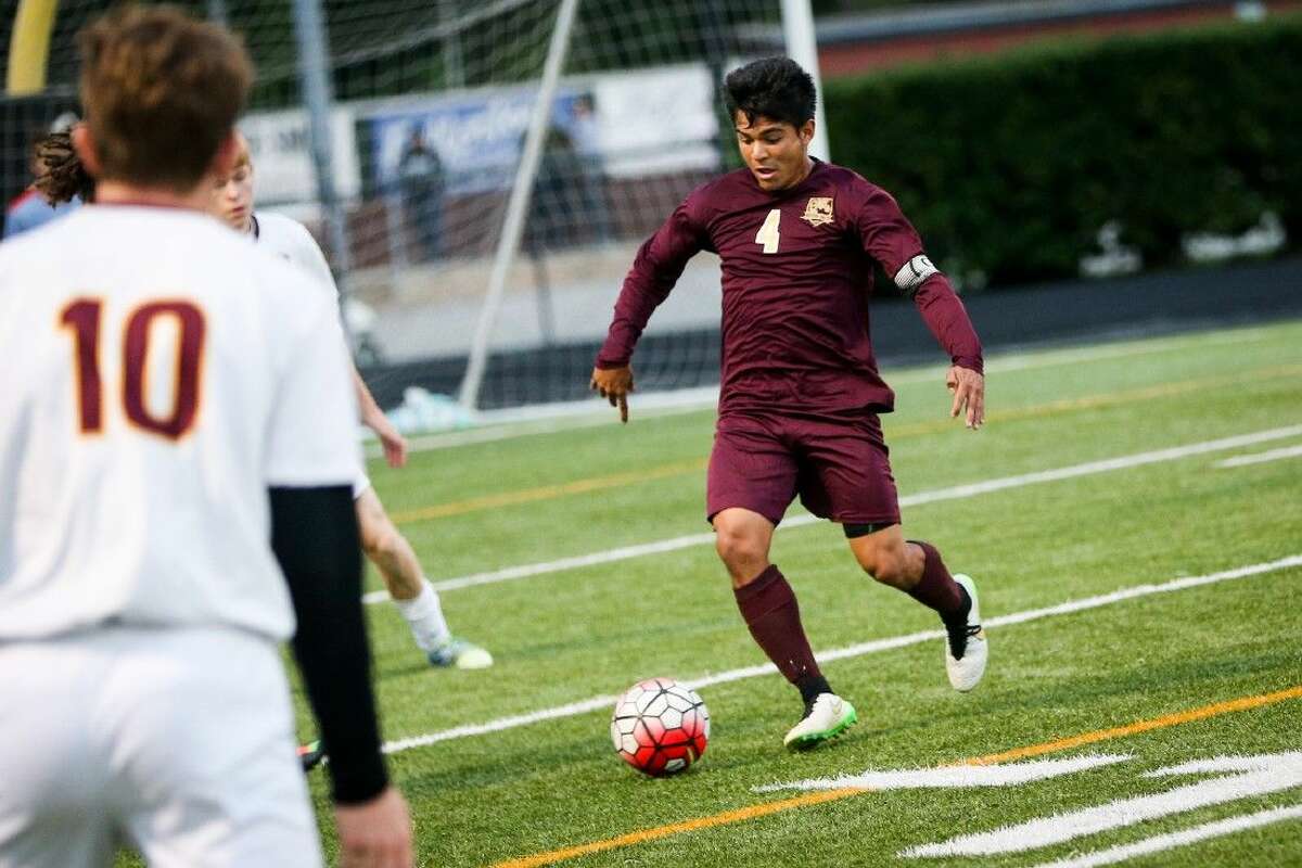 Magnolia West’s Bryan Zavala (4) tries to get past A&M Consolidated defenders during a high school boys soccer game on Friday. To view more photos of the game, go to HCNPics.com.