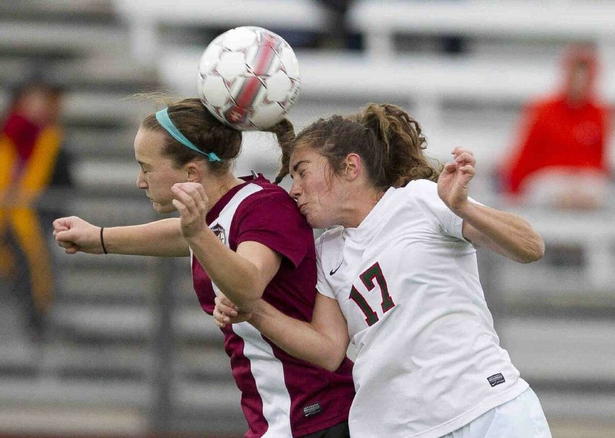 Round Rock's Nicki Springer heads the ball over The Woodlands midfielder Mollie Bond during the first period of a Region II-6A area round playoff game at A&M Consolidated High School Friday in College Station. Go to HCNpics.com to purchase this photo and others like it.