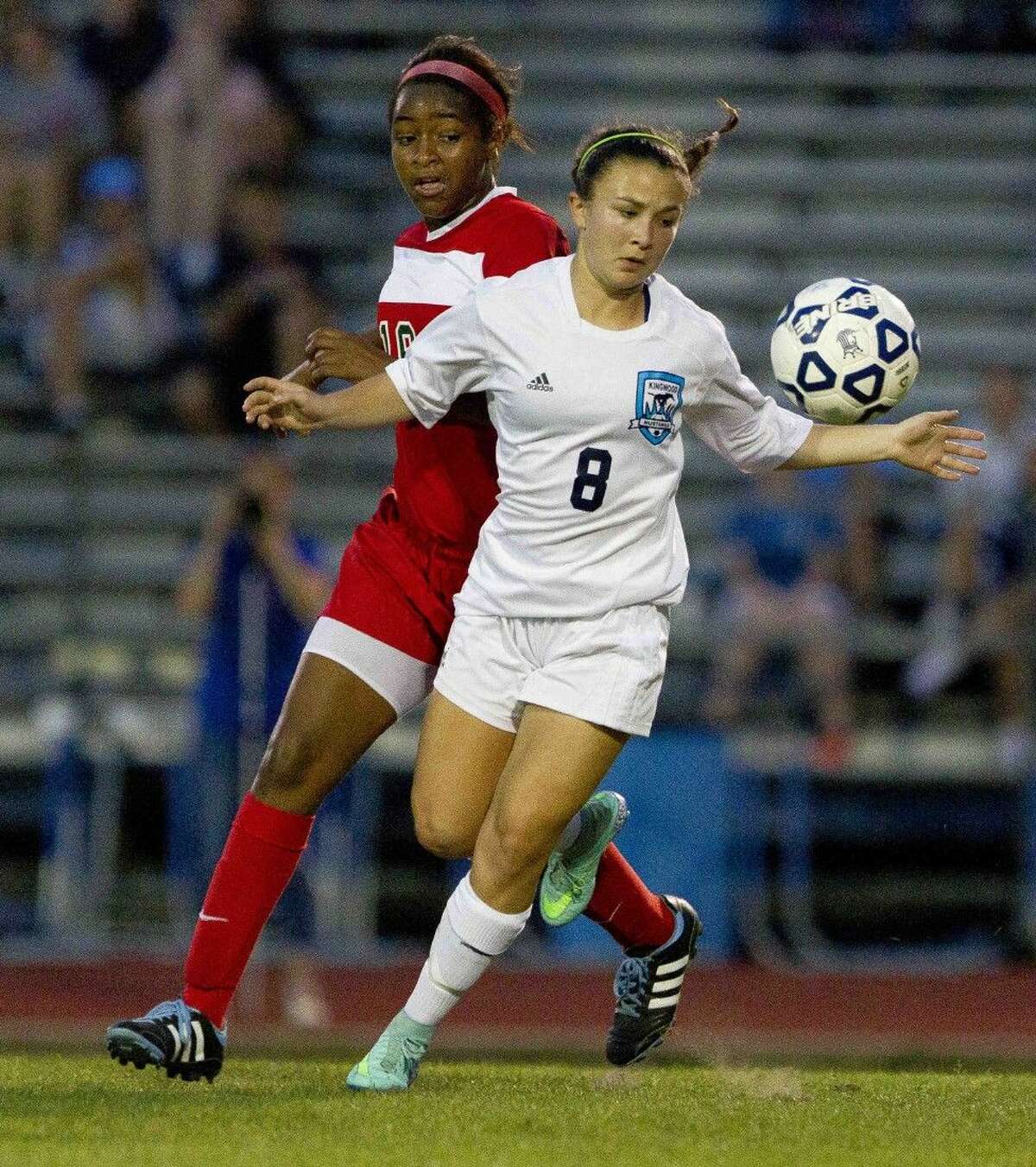Kingwood's Catherine Childs looks to control the ball as The Woodlands forward Jazzy Richards chases her down during the first period of a District 16-6A girls soccer game at Kingwood High School Friday. The Woodlands defeated Kingwood 3-0. Go to HCNpics.com to purchase this photo and others like it.