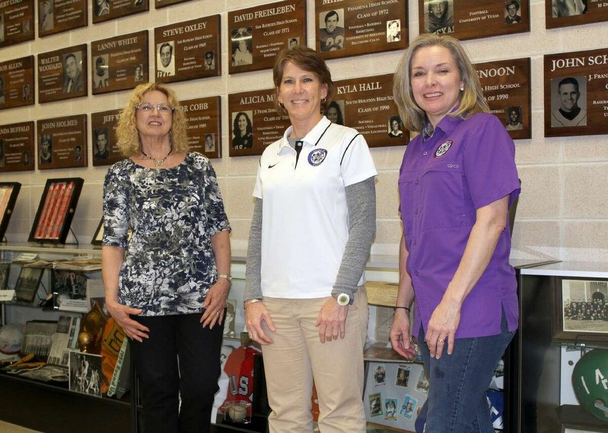 Jana Williams (center), assistant athletics director for the Pasadena ISD, puts the finishing touches on Hall of Fame Museum displays in preparation for the Hall of Fame’s fifth induction banquet this Saturday. Assisting are sports ticket office assistants Cathy Storey and Liz Tolleson.