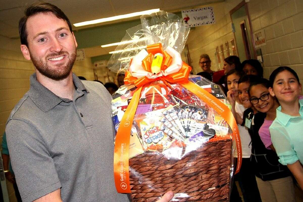 Jessup fourth grade teacher Jason Juneau receives a gift of appreciation from Gulf Coast Educators FCU for being named the Elementary New Teacher of the Year. Photo by Reesha Brown.