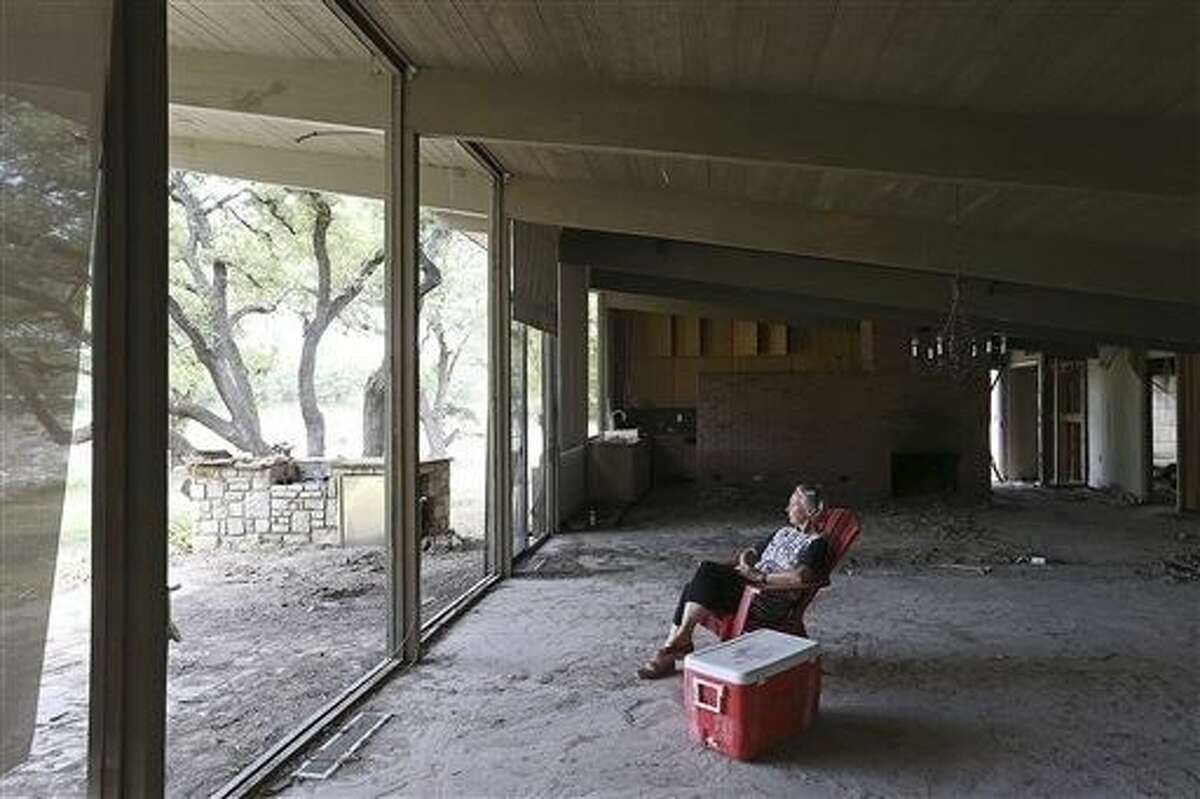 Alice Wightman, 66, looks towards the Blanco River while sitting in the living room of her flood ravaged home in Wimberley, Sunday, July 26. The area was hit with a historical flood on Memorial Day that left 1,200 houses and properties damages including 209 destroyed in Hays County. Twelve people died and two children are missing in the county.
