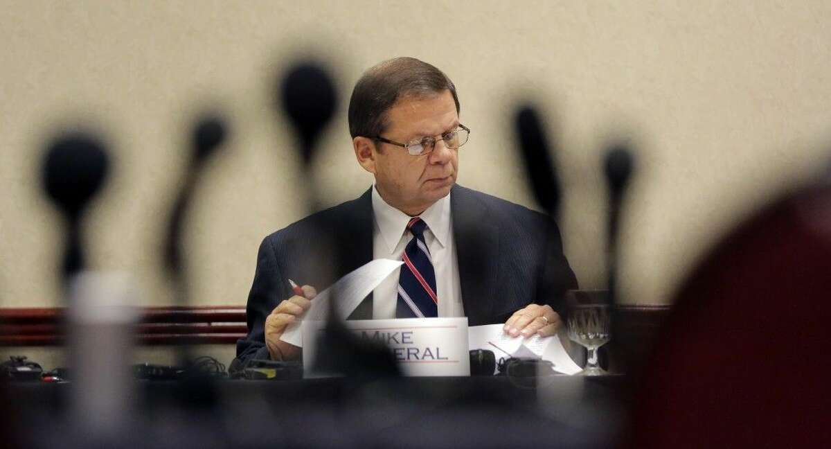 Mike Motheral, chairman of the University Interscholastic League (UIL) State Executive Committee, is seen through a cluster of microphones during an emergency meeting, Wednesday in Round Rock, Texas. The UIL, the governing body for high school sports in Texas, called the meeting to investigate two John Jay High School football players that hit a referee and the surrounding events.