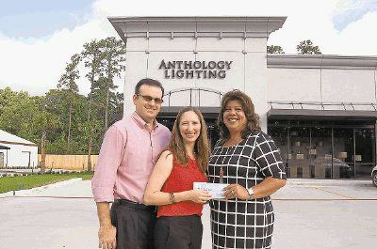Jeff and Michelle Ber, left, owners of the new Anthology Lighting store at 32411 FM 2978 in Magnolia, present a contribution to Isabel McDanel, director of Development for Habitat for Humanity of Montgomery County, as a portion of the sales profits from the recent grand opening this summer.