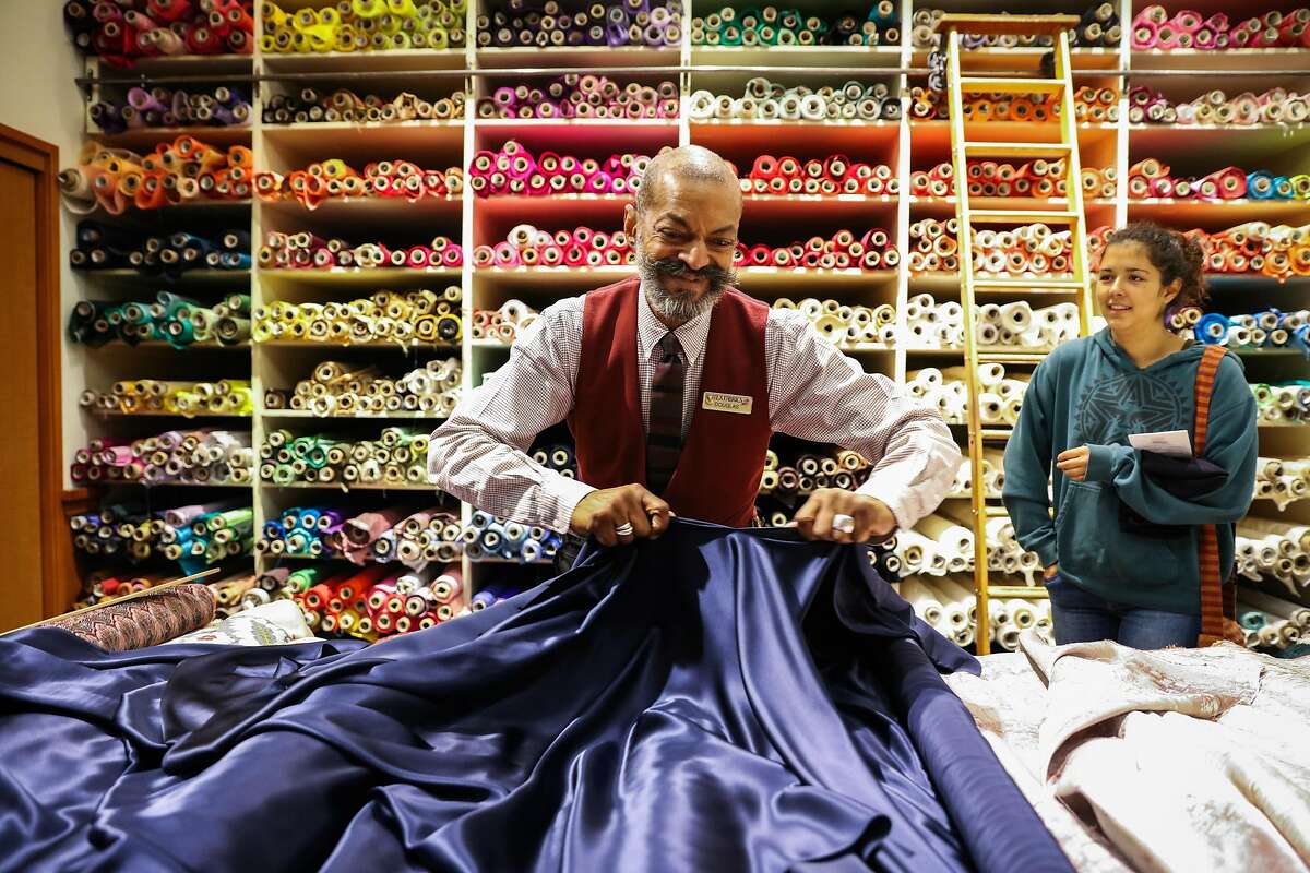 Employee Douglas Davis (left) helps student Sara Scott (right), who has regularly shopped at Britex for three years, buy fabric, at Britex Fabrics, in San Francisco, California, on Wednesday, Oct. 5, 2016.