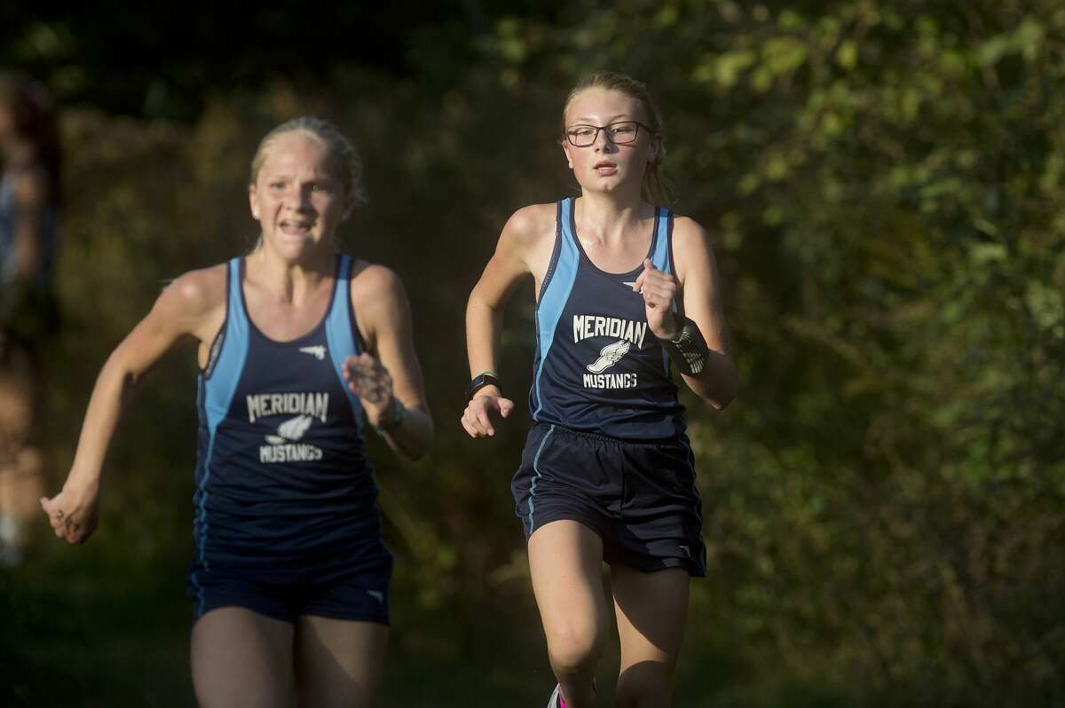 Meridian's Alexis North, left, and Cassidy Forbes race to the finish line in the Jack Pine Jamobree at Samson Farm Wednesday afternoon.