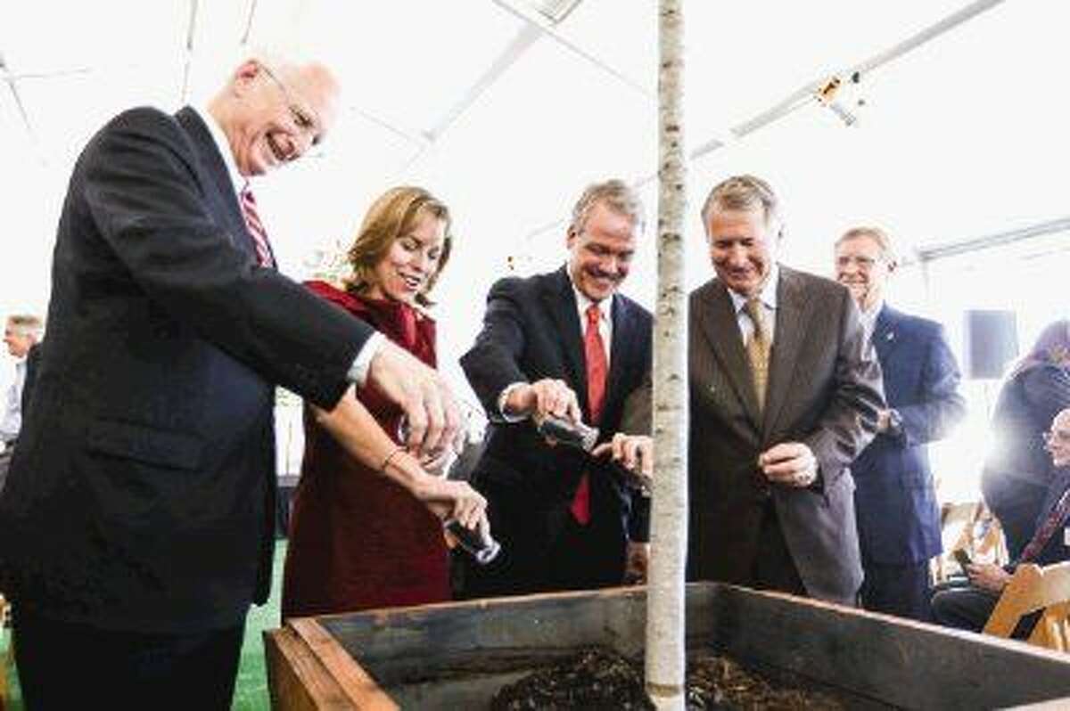 From left to right: Ewing Werlein Jr., Chair of Houston Methodist Board of Directors, Debra Sukin, Regional Senior Vice President of Houston Methodist, Marc Boom, President and CEO of Houston Methodist, and Ed Robb, Senior Pastor at The Woodlands United Methodist Church, pour soil around a tree during the Houston Methodist The Woodlands Hospital groundbreaking ceremony on Tuesday, Oct. 21, 2014, off of I-45 North in The Woodlands.