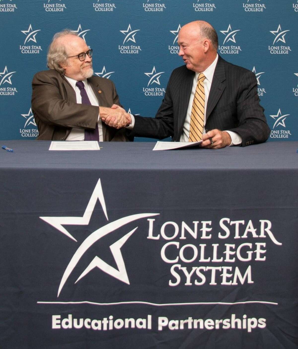Dr. Richard Berry, Steven F. Austin University provost and vice president of academic affairs (pictured left) shakes hands with Steven C. Head Ph.D., Lone Star College chancellor after signing an articulation agreement to formalize a pathway for easier student transfers from a two-year degree at LSC on to a four-year degree at SFA.
