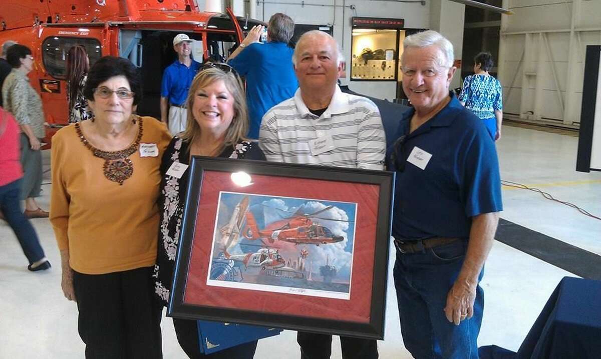 U.S. Coast Guard Air Station Houston Executive Officer, Commander Christopher Hulser, spoke to the volunteers about what their service means to troops and military family members before presenting a lithograph to USO Houston Volunteers of the Year, Richard and Nancy Foisner.