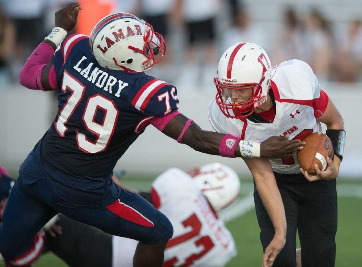 Lamar defensive tackle Joshua Landry applies pressure on Bellaire quarterback John Hubbell during the first half of the Texans’ 31-14 triumph over the Cardinals Saturday night.