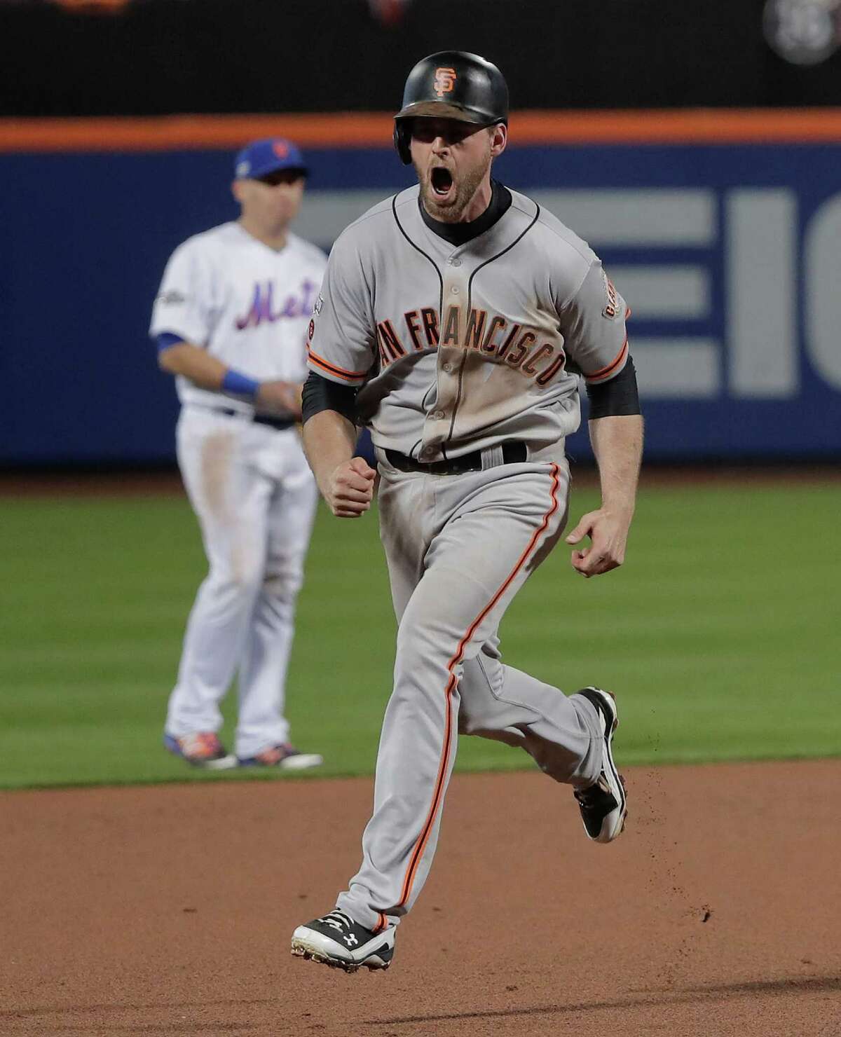 The Giants' heroes were unlikely and expected as No. 8 hitter Conor Gillaspie, left, smacked a three-run homer in the ninth inning to back the shutout pitching of postseason stalwart Madison Bumgarner.