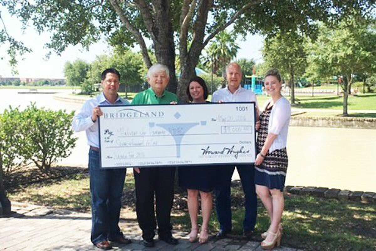 Executives from Bridgeland and The Woodlands Development Company present Habitat for Humanity Northwest Harris County (NWHC) with a 7,000 donation from proceeds from Nature Fest. From left to right are Heath Melton, Vice President of Master Planned Communities, Residential Development for The Woodlands Development Company; Chad Greer, Director of Development for Habitat for Humanity NWHC; Lona Shipp, Marketing Manager for Bridgeland; Peter Houghton, Vice President of Master Planned Communities for Bridgeland; and Audrey Seykora, Digital Marketing Manager for The Woodlands Development Company.