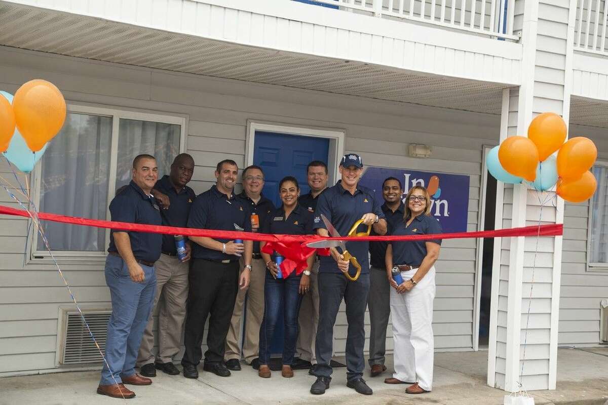 The CEO of InTown Suites, Jonathan Pertchik, surrounded by company team members, cuts the ribbon celebrating the grand reopening of the newly renovated property at 8735 FM 1960 on Thursday, Oct. 22.