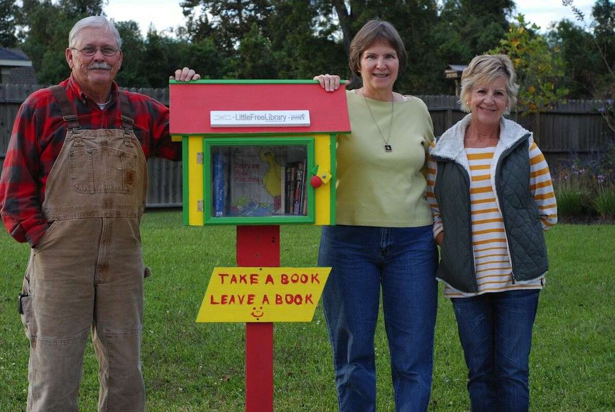 Lynn and Lori Williams, here with their friend Susan Simmons at right, have put up a “Little Free Library” in front of their home in the Fordland Estates neighborhood of Dayton.