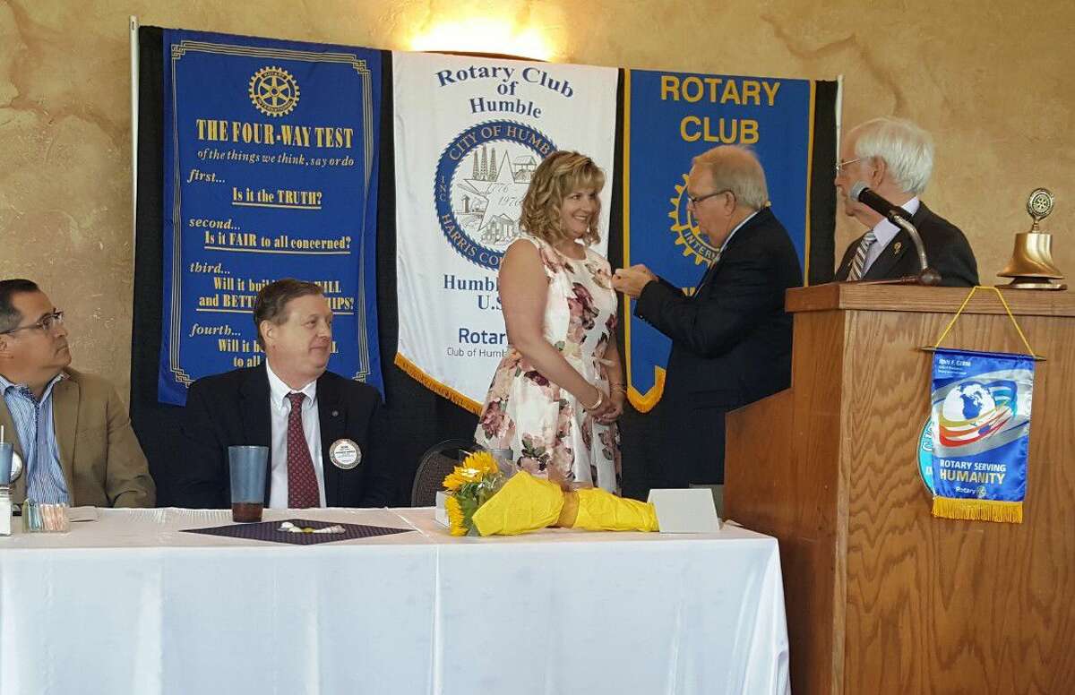 Former Humble Rotary President Oran Bain attaches the Pin of the President to Pam McNair’s lapel during the Officer and Director Installation Ceremony at the Humble Civic Center Wednesday, June 8, 2016.