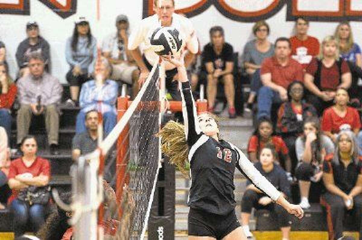Austin's Mallory Nicholson tips a shot over the net against Dulles, Oct. 20 at Austin High School. The Lady Bulldogs won the match to clinch their third consecutive district championship. To view or purchase this photo and others like it, visit HCNpics.com.
