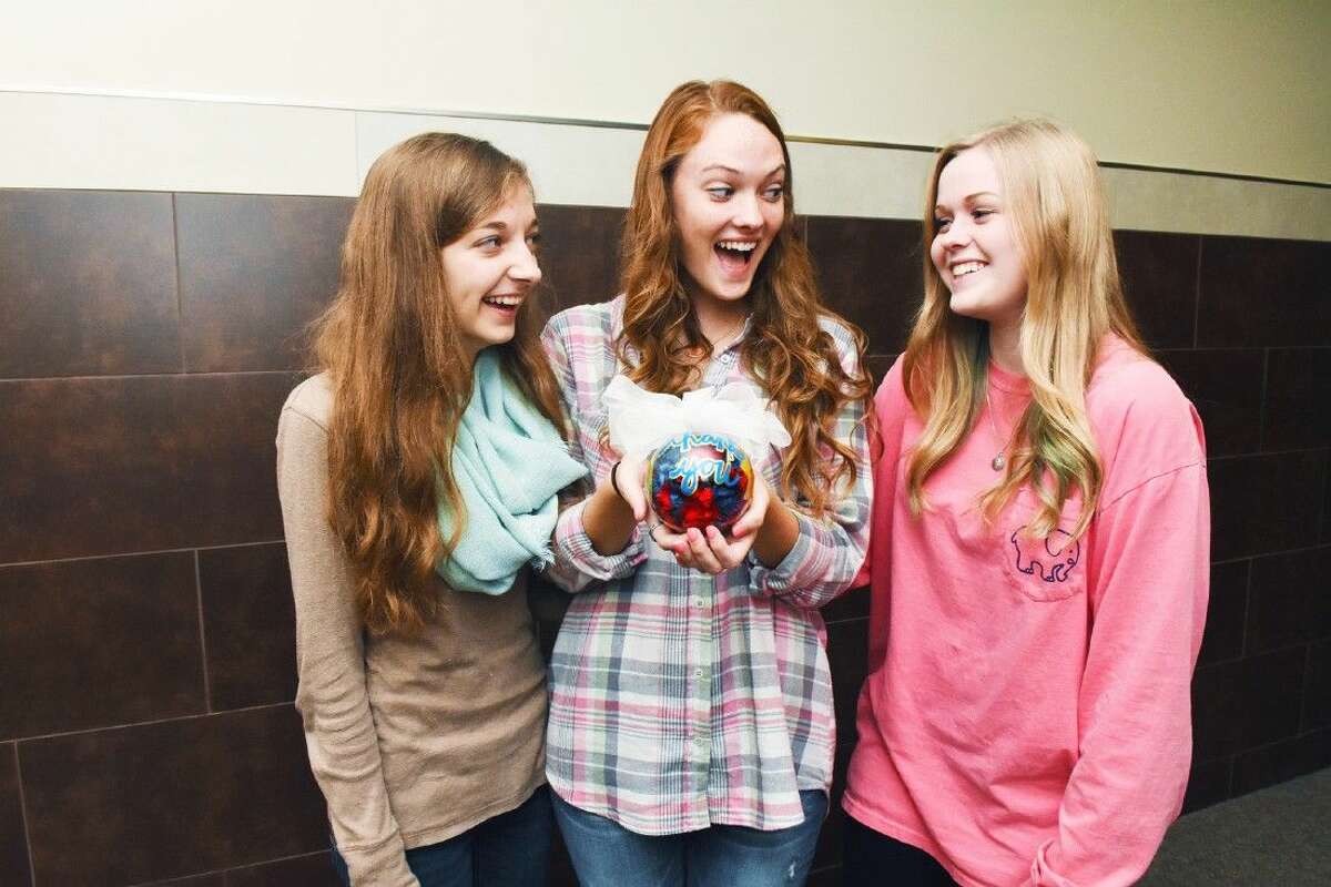 Klein High School are students Emma Gehring, Gracie Mikel and Sarah Horton admire the ornament they created.